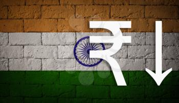 symbolic depreciation of the national currency Rupee against of the country flag of India. Concept of depreciation of currency, economy fall and the breakdown of economic ties
