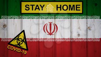 Flag of the Iran in original proportions. Quarantine and isolation - Stay at home. flag with biohazard symbol and inscription COVID-19.