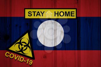 Flag of the Laos in original proportions. Quarantine and isolation - Stay at home. flag with biohazard symbol and inscription COVID-19.
