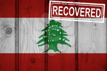 flag of Lebanon that survived or recovered from the infections of corona virus epidemic or coronavirus. Grunge flag with stamp Recovered