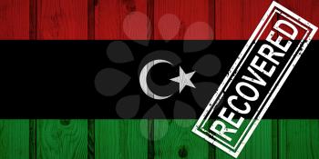 flag of Libya that survived or recovered from the infections of corona virus epidemic or coronavirus. Grunge flag with stamp Recovered