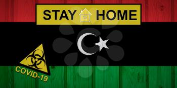Flag of the Libya in original proportions. Quarantine and isolation - Stay at home. flag with biohazard symbol and inscription COVID-19.