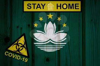 Flag of the Macau in original proportions. Quarantine and isolation - Stay at home. flag with biohazard symbol and inscription COVID-19.