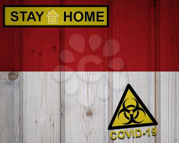 Flag of the Monaco in original proportions. Quarantine and isolation - Stay at home. flag with biohazard symbol and inscription COVID-19.