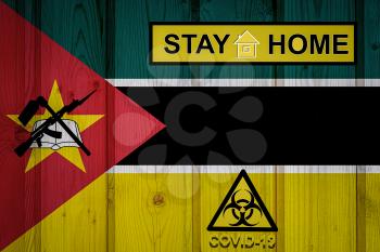 Flag of the Mozambique in original proportions. Quarantine and isolation - Stay at home. flag with biohazard symbol and inscription COVID-19.