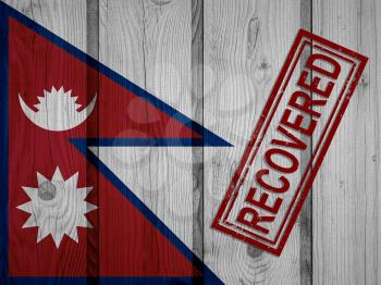 flag of Nepal that survived or recovered from the infections of corona virus epidemic or coronavirus. Grunge flag with stamp Recovered