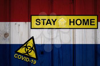 Flag of the Netherlands in original proportions. Quarantine and isolation - Stay at home. flag with biohazard symbol and inscription COVID-19.