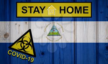Flag of the Nicaragua in original proportions. Quarantine and isolation - Stay at home. flag with biohazard symbol and inscription COVID-19.
