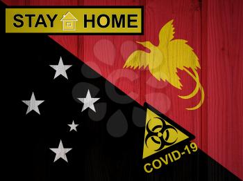 Flag of the Papua New Guinea in original proportions. Quarantine and isolation - Stay at home. flag with biohazard symbol and inscription COVID-19.