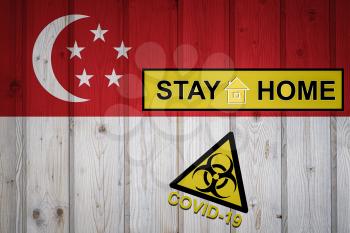 Flag of the Singapore in original proportions. Quarantine and isolation - Stay at home. flag with biohazard symbol and inscription COVID-19.