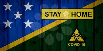 Flag of the Solomon Islands in original proportions. Quarantine and isolation - Stay at home. flag with biohazard symbol and inscription COVID-19.