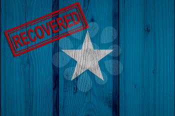 flag of Somalia that survived or recovered from the infections of corona virus epidemic or coronavirus. Grunge flag with stamp Recovered
