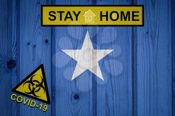 Flag of the Somalia in original proportions. Quarantine and isolation - Stay at home. flag with biohazard symbol and inscription COVID-19.