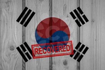 flag of South Korea that survived or recovered from the infections of corona virus epidemic or coronavirus. Grunge flag with stamp Recovered