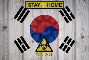 Flag of the South Korea in original proportions. Quarantine and isolation - Stay at home. flag with biohazard symbol and inscription COVID-19.