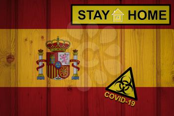 Flag of the spain in original proportions. Quarantine and isolation - Stay at home. flag with biohazard symbol and inscription COVID-19.