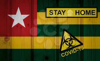 Flag of the Togo in original proportions. Quarantine and isolation - Stay at home. flag with biohazard symbol and inscription COVID-19.