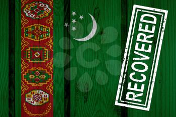 flag of Turkmenistan that survived or recovered from the infections of corona virus epidemic or coronavirus. Grunge flag with stamp Recovered