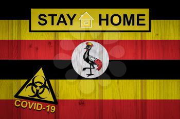 Flag of the Uganda in original proportions. Quarantine and isolation - Stay at home. flag with biohazard symbol and inscription COVID-19.
