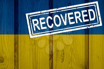 flag of Ukraine that survived or recovered from the infections of corona virus epidemic or coronavirus. Grunge flag with stamp Recovered