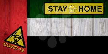 Flag of the United Arab Emiratesin original proportions. Quarantine and isolation - Stay at home. flag with biohazard symbol and inscription COVID-19.