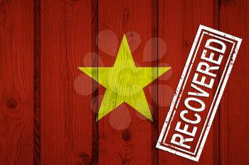 flag of Vietnam that survived or recovered from the infections of corona virus epidemic or coronavirus. Grunge flag with stamp Recovered