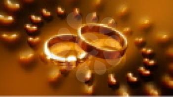 Royalty Free Video of Rotating Wedding Rings Surrounded by Rotating Hearts